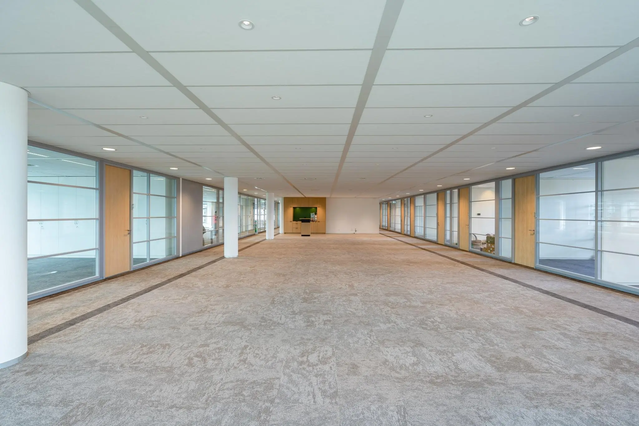 Ruime, lege kantoorruimte aan de Fascinatio Boulevard met glazen wanden en een licht interieur.